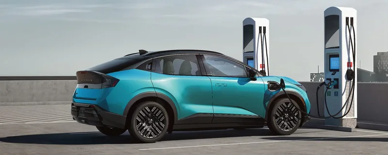 Blue third-generation 2026 LEAF connected to an EV charging station