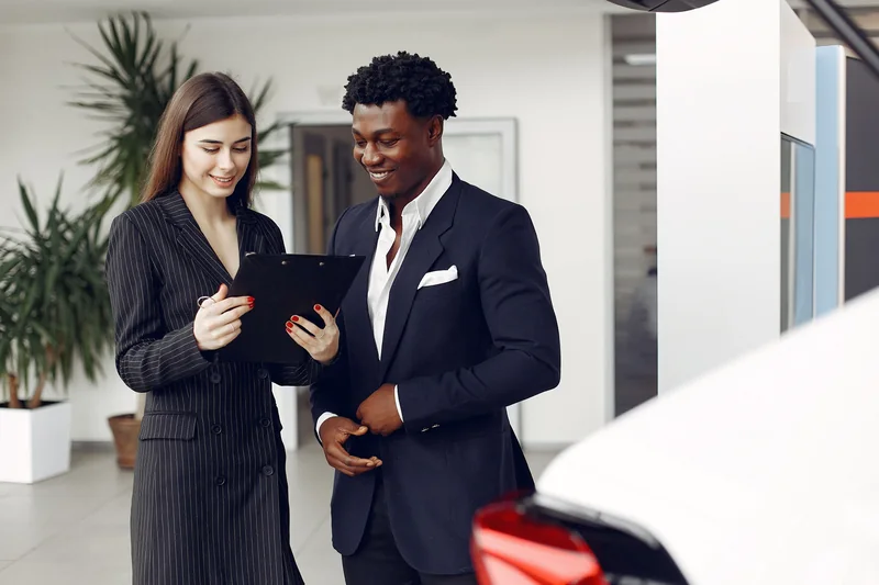 Dealer and customer reviewing a tablet in a showroom