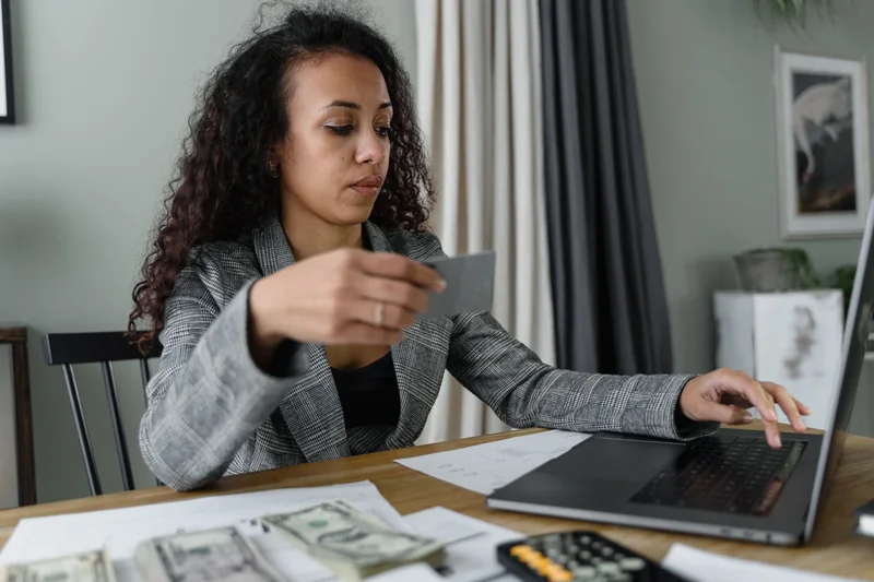 A woman reviewing her budget at a laptop