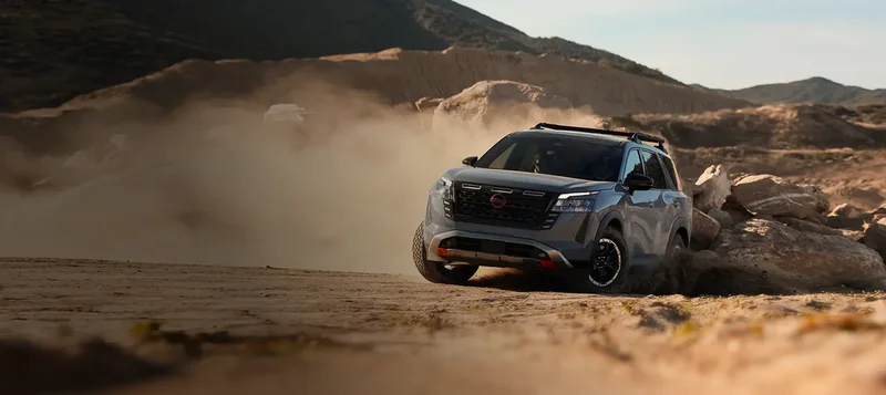 Gray Pathfinder Rock Creek kicking up dust on rocky desert terrain