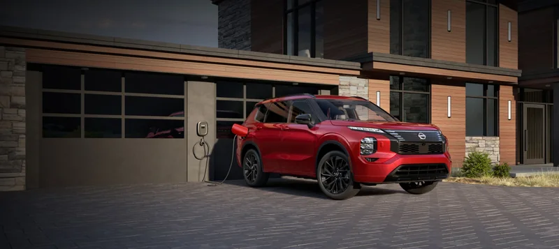 Red 2026 Rogue Plug-in Hybrid parked in a modern home driveway