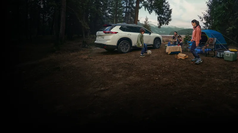 White Rogue parked at a family campsite in a wooded setting