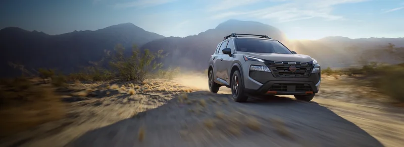 Silver 2026 Rogue Plug-in Hybrid driving toward the viewer on a desert road