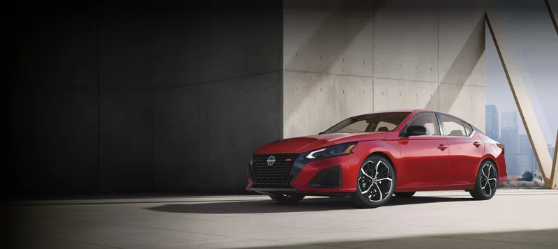 Red Altima parked in a modern parking structure
