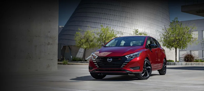 Red Versa parked outside a modern building