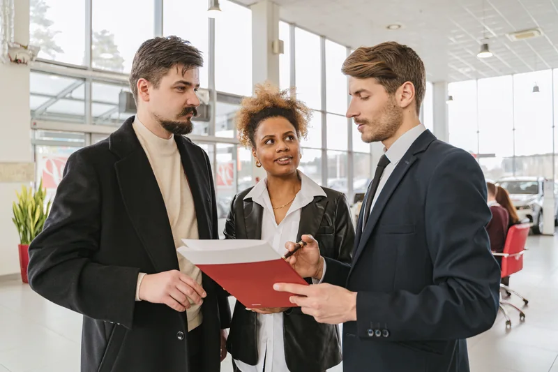 Dealer consulting a couple in a showroom
