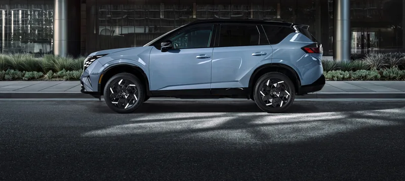 Silver 2027 Rogue Hybrid in side profile outside a modern city building