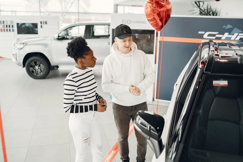 Two shoppers examining a vehicle in a showroom