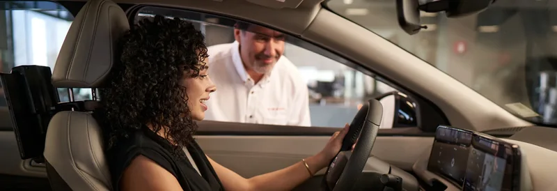 Nissan service advisor talking to driver through vehicle window
